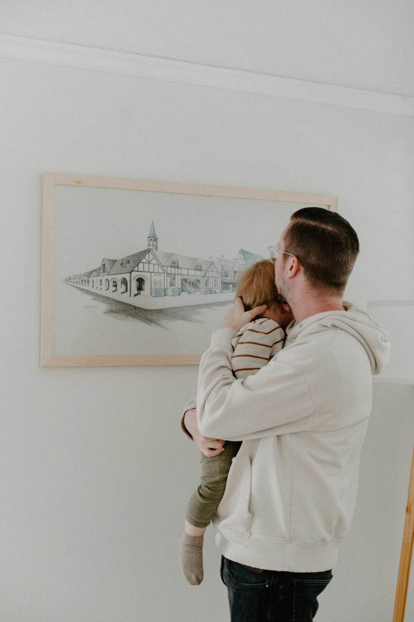 father and son in front of a neutral wood picture frame