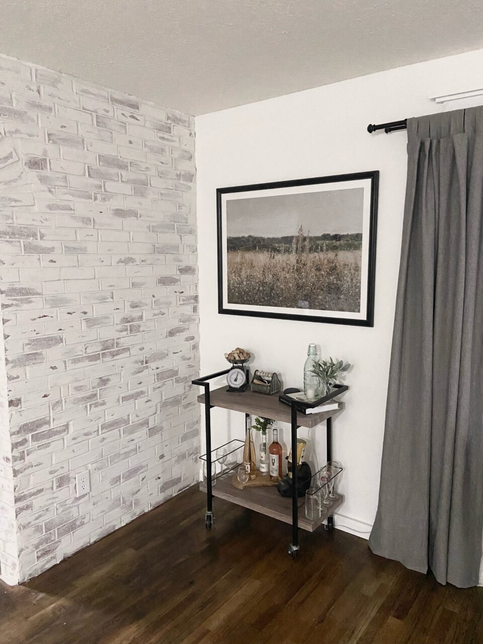 black picture frame above a bar cart 