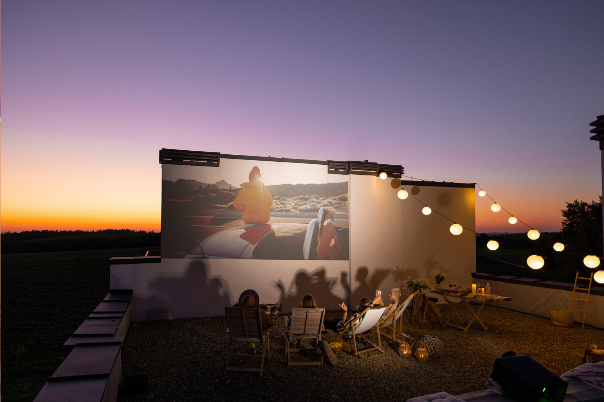 outdoor living space with projector and string lights