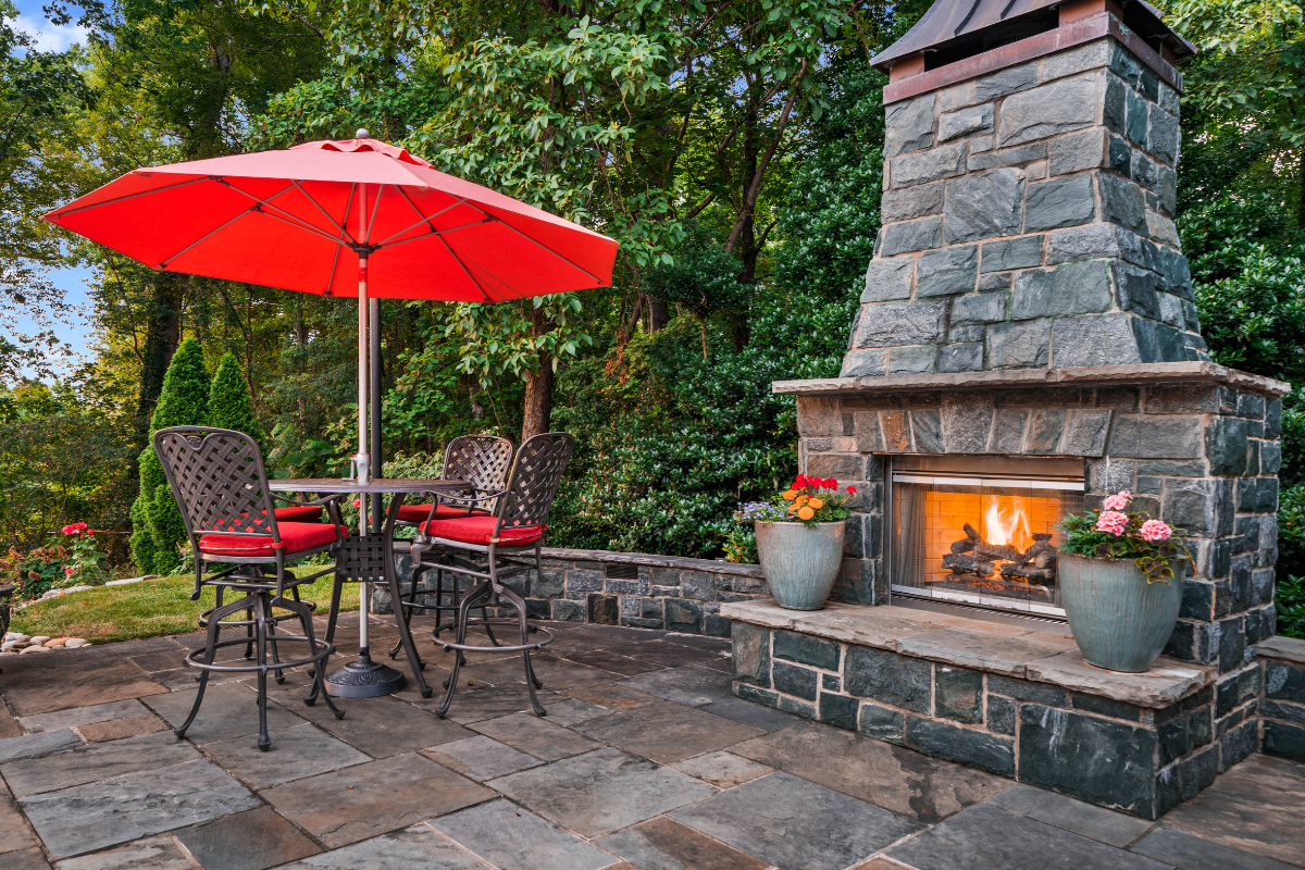 outdoor patio with fireplace and umbrella