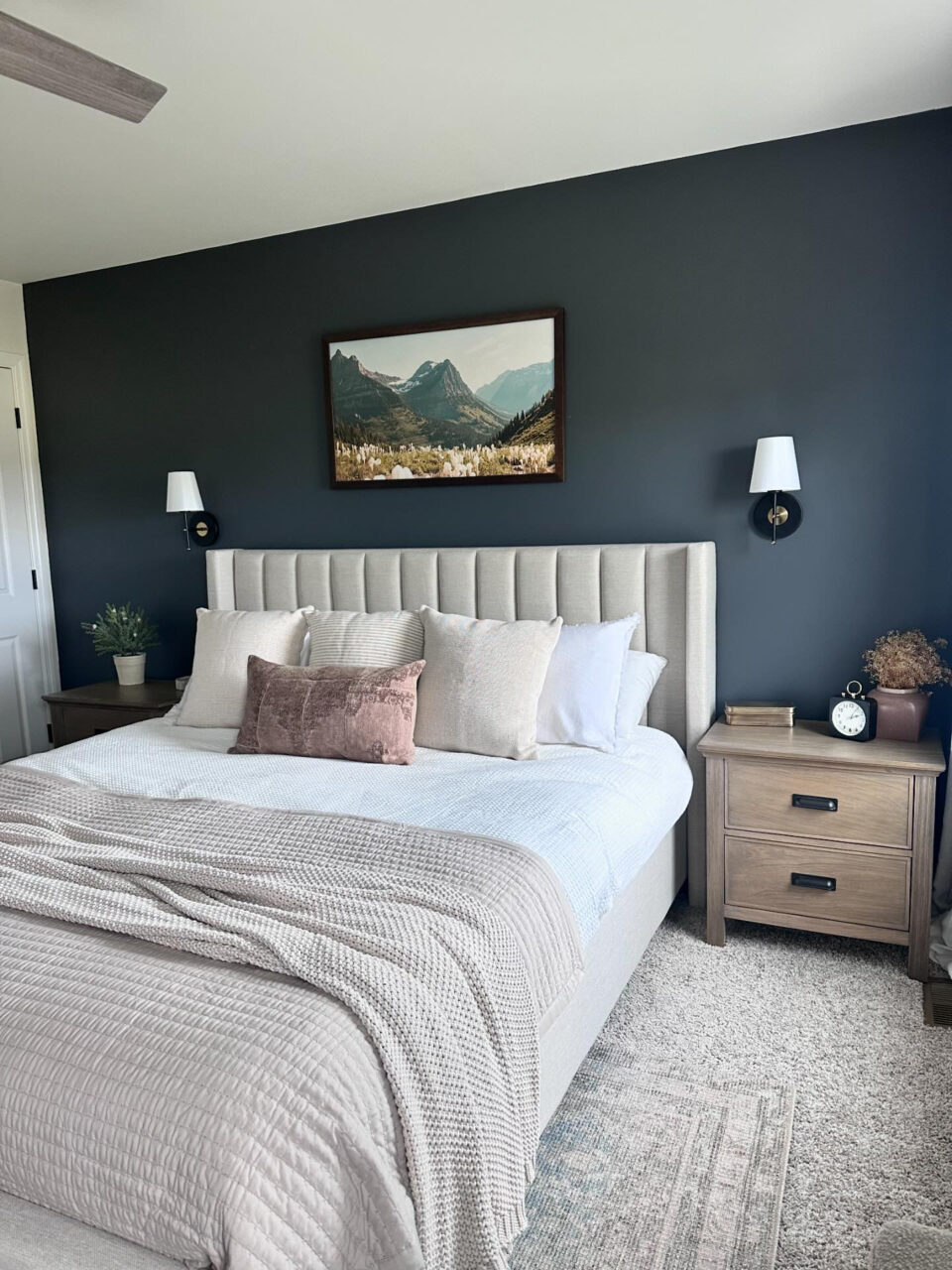 bedroom with dark walls and large framed art above bed